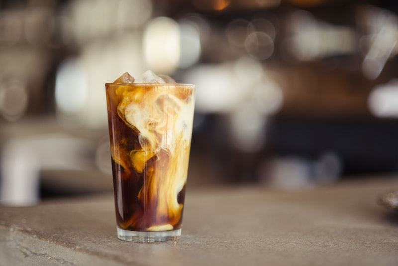 A tall glass of iced cold brew coffee with ice cubes